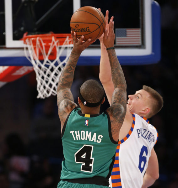 New York Knicks forward Kristaps Porzingis (6) defends as Boston Celtics guard Isaiah Thomas (4) shoots during the first half of an NBA basketball game at Madison Square Garden in New York, Tuesday, Jan. 12, 2016. (AP Photo/Kathy Willens)